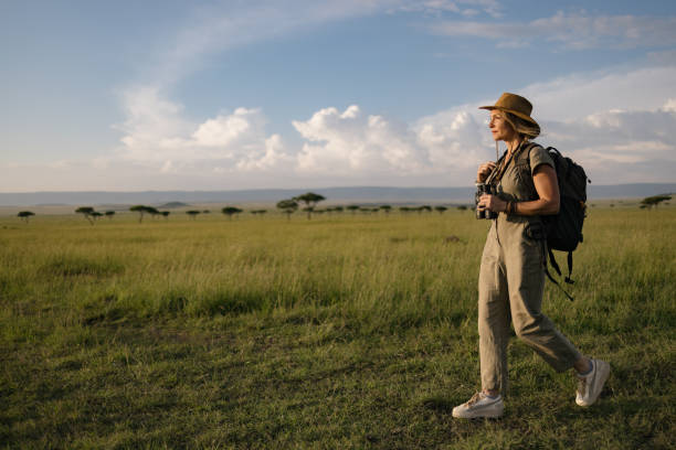 Carefree female explorer walking through Masai Mara National reserve in Kenya. A woman walking in Masai Mara National Reserve